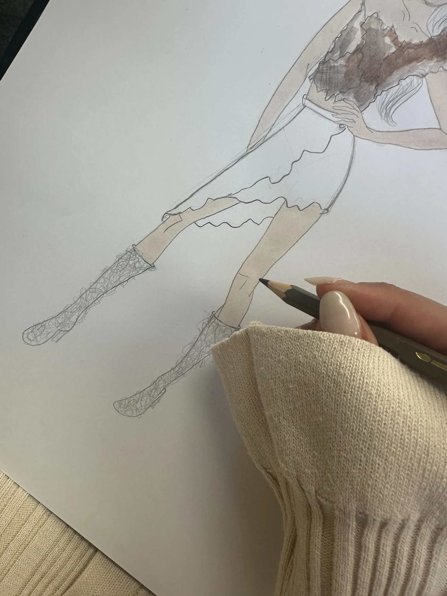 Pencil lines of a fashion sketch beside a natural fabric swatch